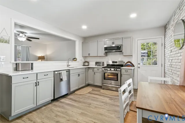 a kitchen with granite countertop a sink cabinets and stainless steel appliances