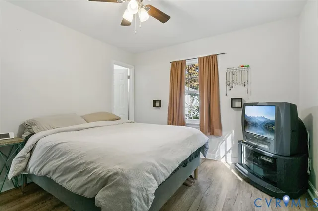 a bedroom with a bed and a flat tv screen on a dresser