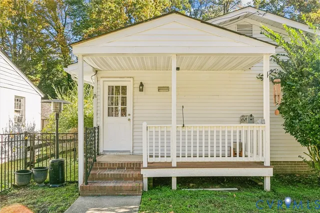 a white house with a small yard and plants