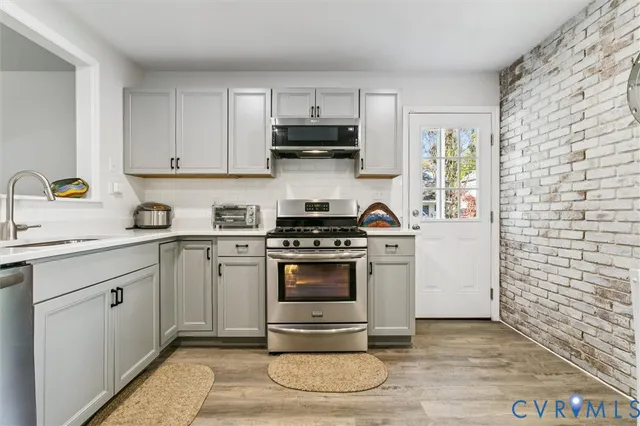 a kitchen with a stove a sink and a microwave
