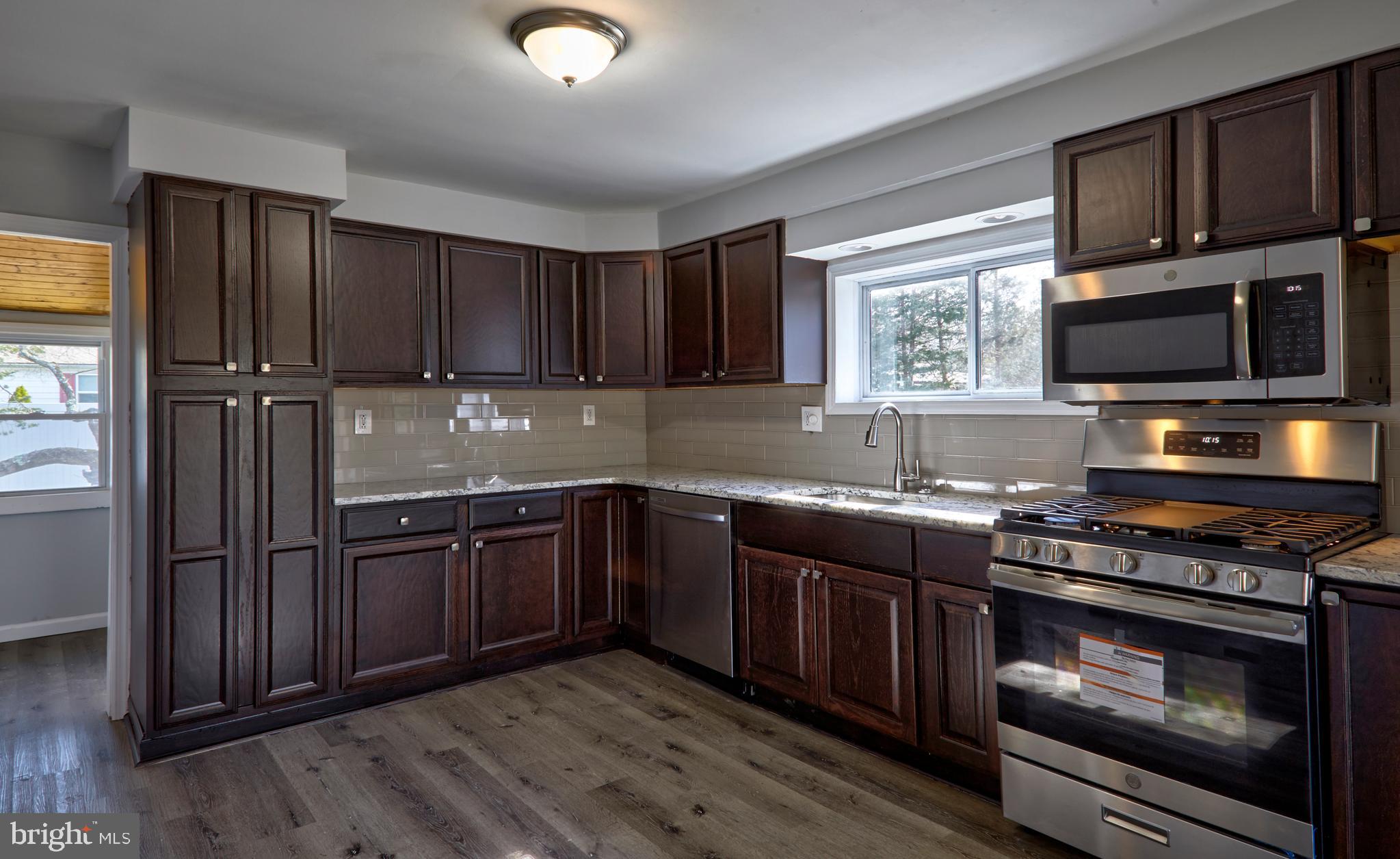 44 Cedarbrook Road Sicklerville, NJ 08081 - Photo 2 of 25 a kitchen with stainless steel appliances granite countertop wooden cabinets stove top oven and sink