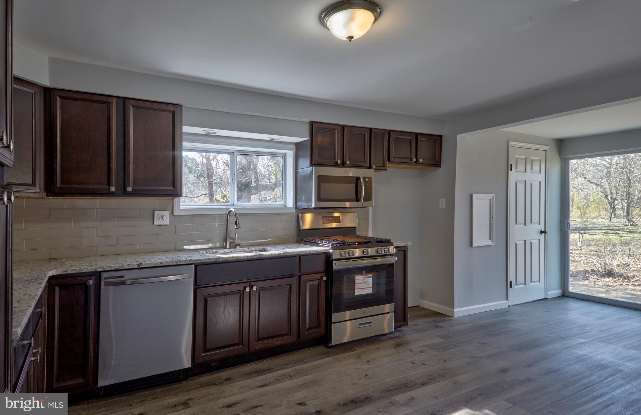 44 Cedarbrook Road Sicklerville, NJ 08081 - Photo 4 of 25 a kitchen with stainless steel appliances granite countertop a sink a stove a refrigerator cabinets and wooden floor