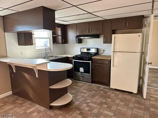 a kitchen with stainless steel appliances a sink a stove a refrigerator and cabinets