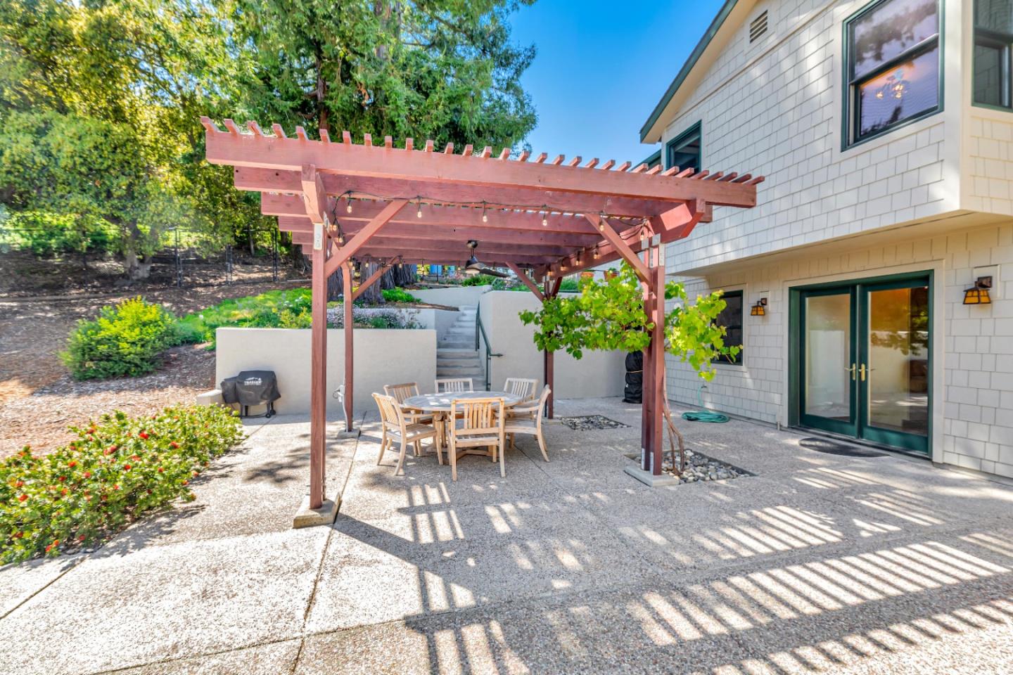 22820 San Juan Road Cupertino, CA 95014 - Photo 52 of 100 a view of a patio with table and chairs under an umbrella