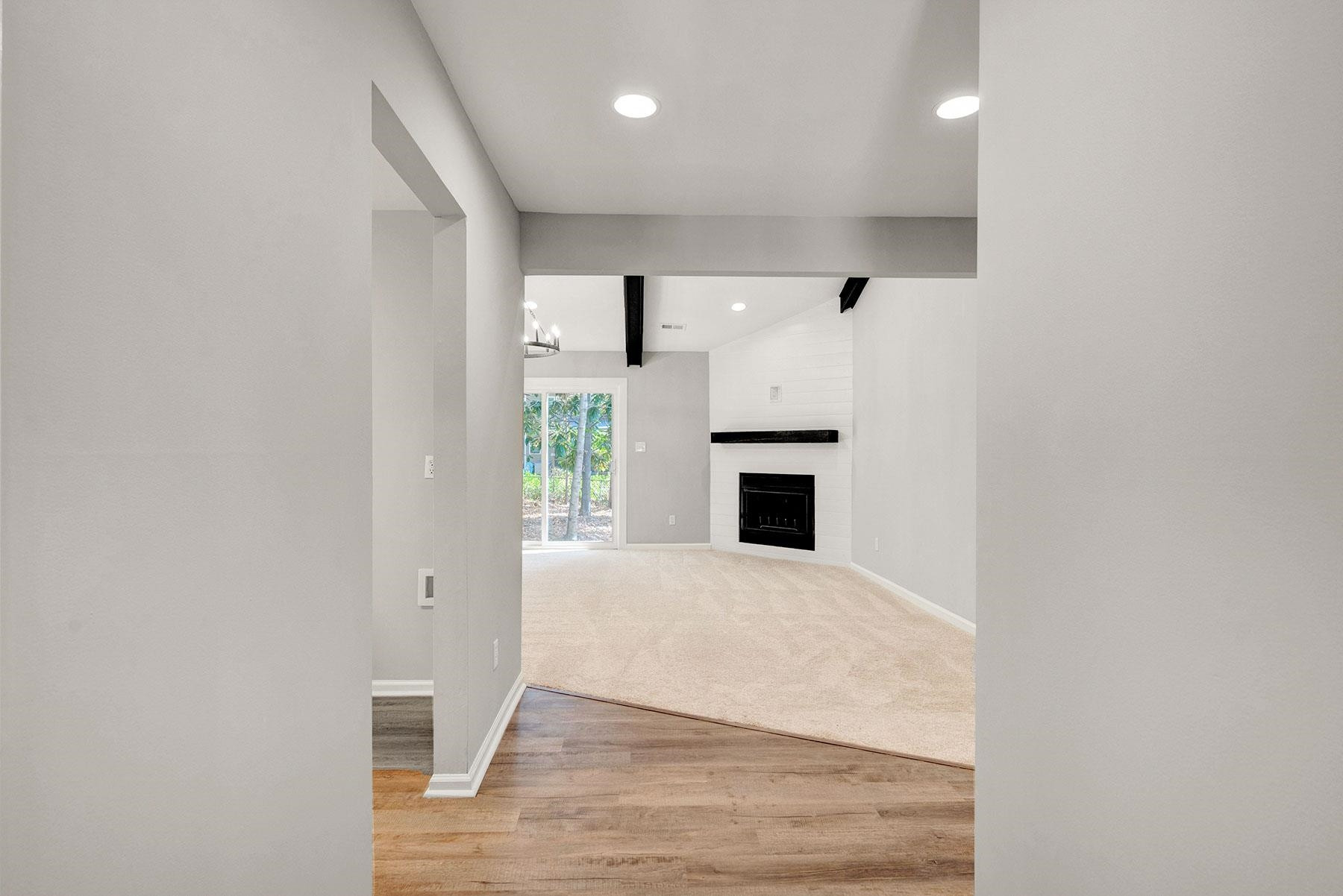 6500 Hammersmith Drive Raleigh, NC 27613 - Photo 3 of 21 an empty room with wooden floor and fireplace