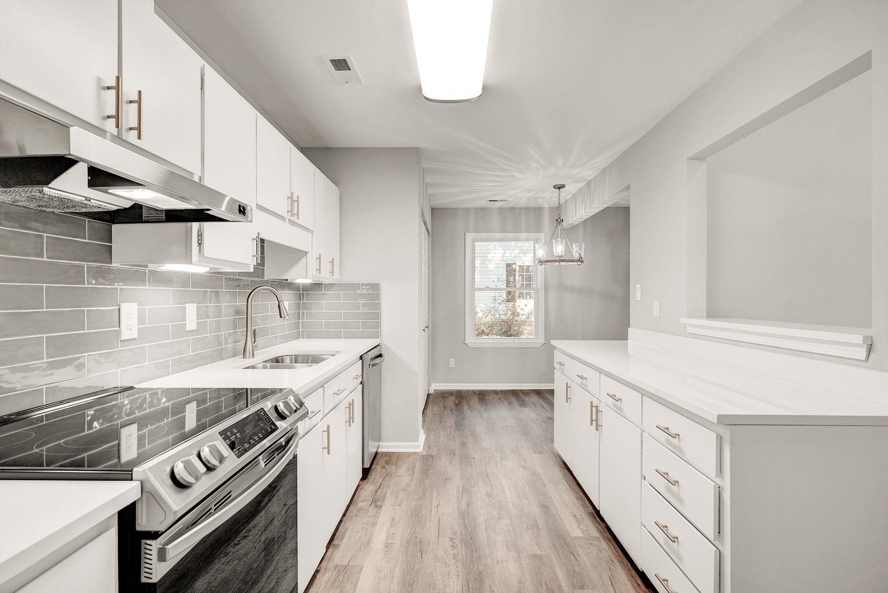 6500 Hammersmith Drive Raleigh, NC 27613 - Photo 4 of 21 a kitchen with stainless steel appliances granite countertop a stove and a white cabinets