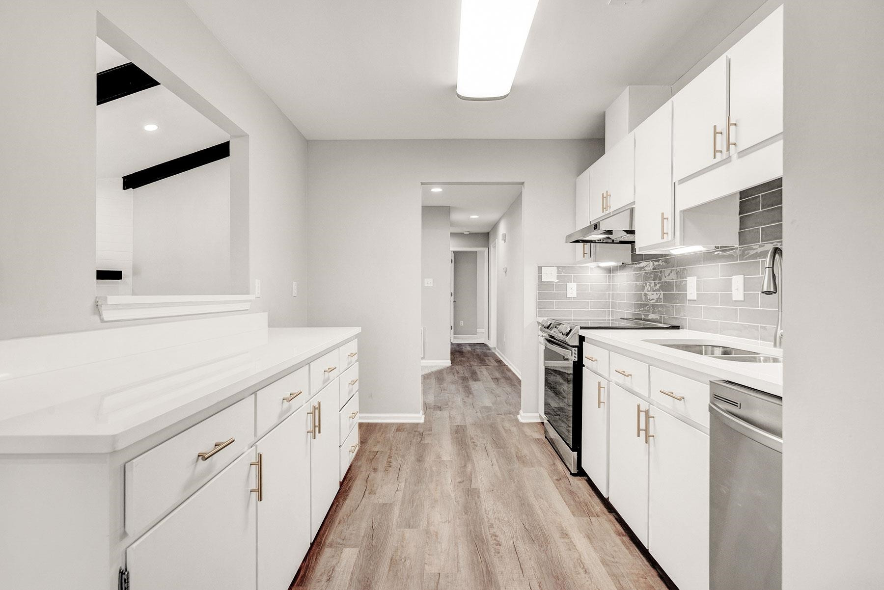 6500 Hammersmith Drive Raleigh, NC 27613 - Photo 5 of 21 a large white kitchen with cabinets and stainless steel appliances