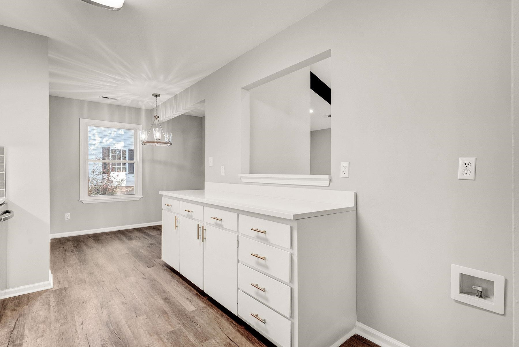 6500 Hammersmith Drive Raleigh, NC 27613 - Photo 7 of 21 a hallway with white cabinets and wooden floor