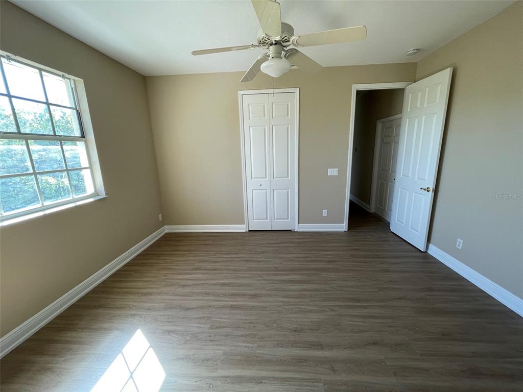 10365 Pendleton Avenue Englewood, FL 34224 - Photo 8 of 9 an empty room with wooden floor and windows