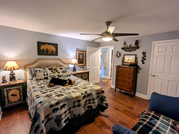 a bedroom with a bed a dresser next to a window