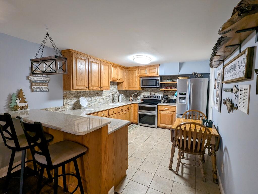 96 Cascade Trail, Unit 24 Fancy Gap, VA 24328 - Photo 5 of 18 a kitchen with stainless steel appliances granite countertop a stove a refrigerator a kitchen island a dining table and chairs with wooden floor