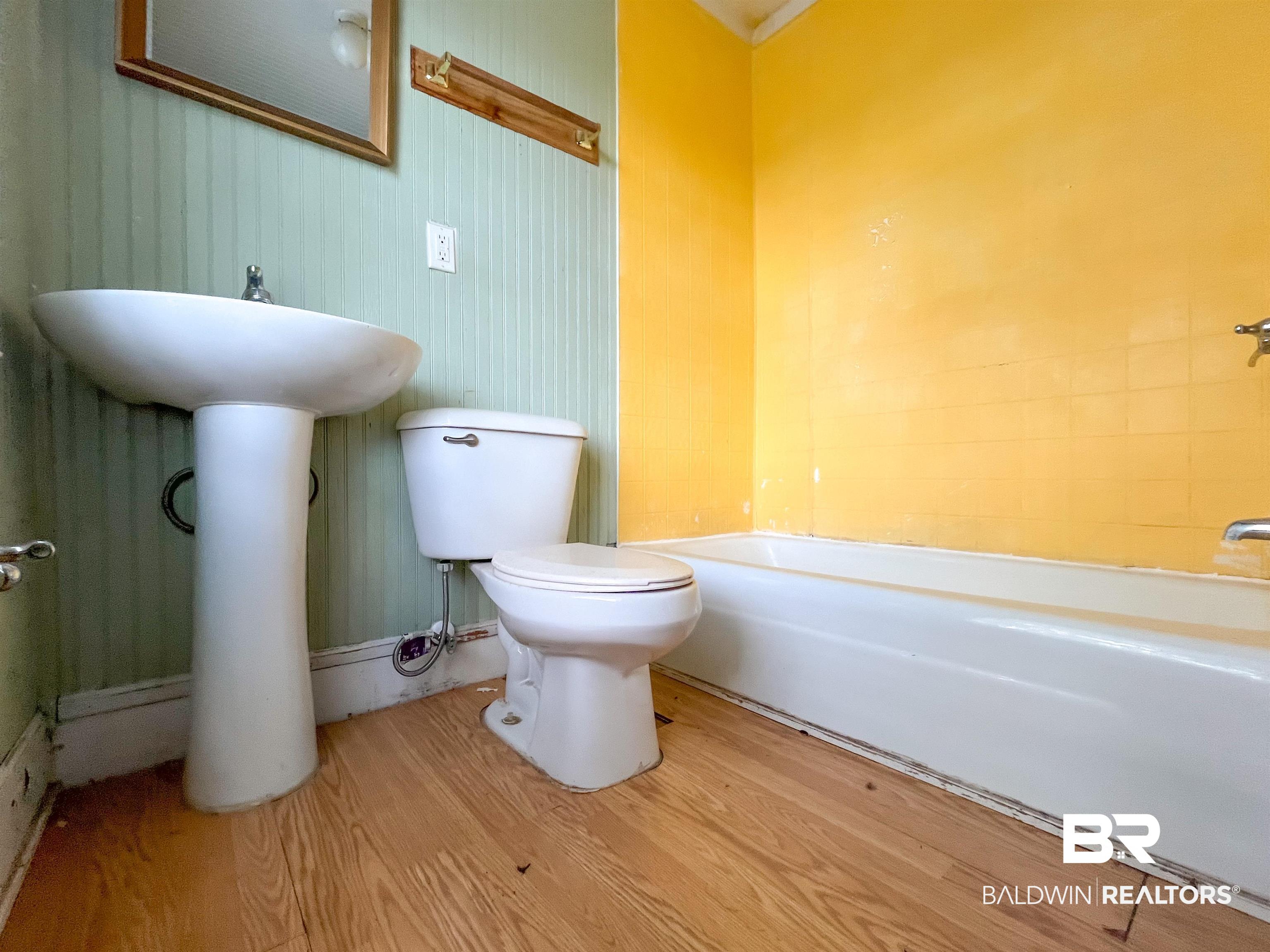 12956 Bender Road Foley, AL 36535 - Photo 32 of 46 Full bathroom with hardwood / wood-style flooring, bathtub / shower combination, toilet, and sink