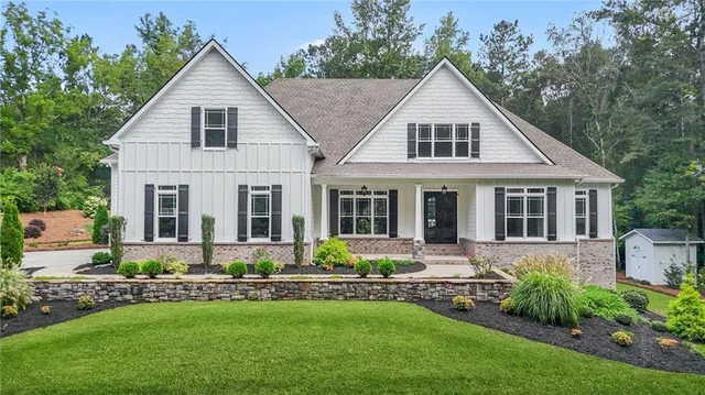 a front view of a house with a yard and potted plants