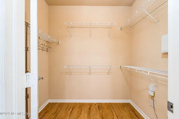 a view of walk in closet with window and small yard