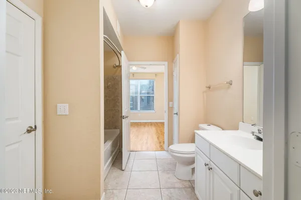 a bathroom with a sink a toilet and a large mirror