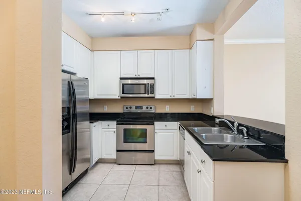 a kitchen with stainless steel appliances granite countertop a sink and a stove