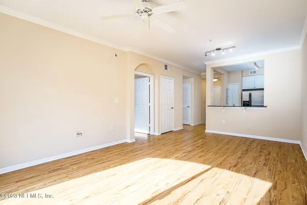 a view of a livingroom with wooden floor and a ceiling fan