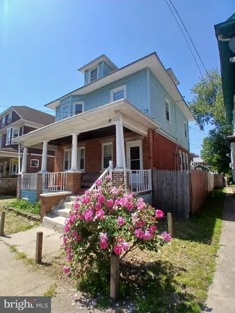 a front view of a house with a yard and a garden