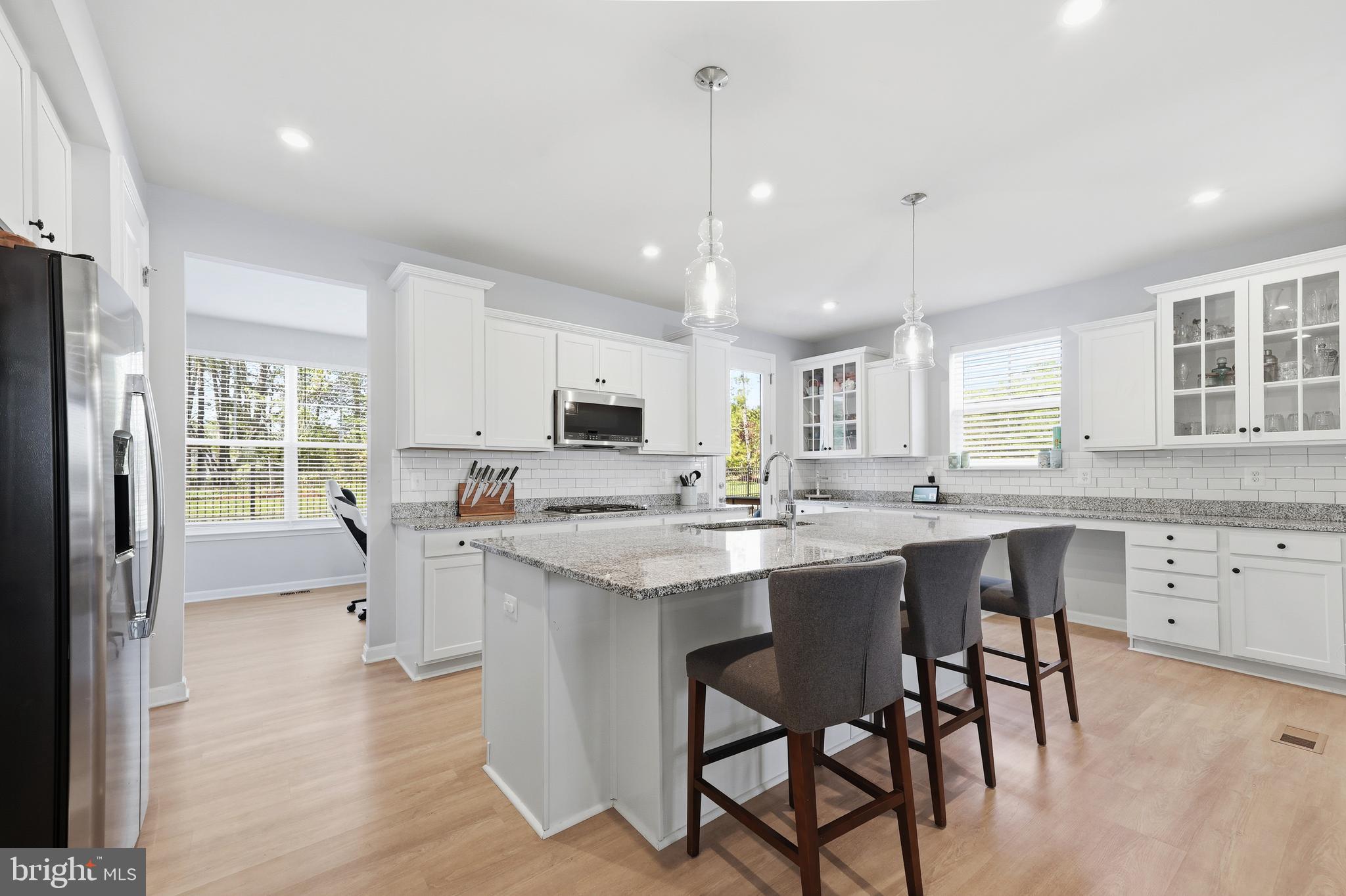 18319 Summit Pointe Drive Triangle, VA 22172 - Photo 7 of 40 a kitchen with stainless steel appliances a dining table chairs stove refrigerator and cabinets