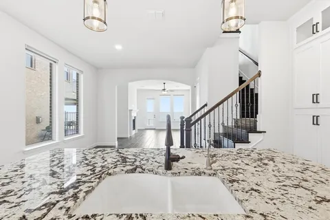 a view of a hallway with wooden floor and chandelier