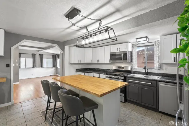 a kitchen with stainless steel appliances granite countertop a sink a stove and refrigerator