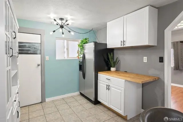 a kitchen with a table chairs refrigerator and cabinets