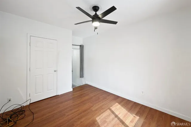 an empty room with a window and a ceiling fan