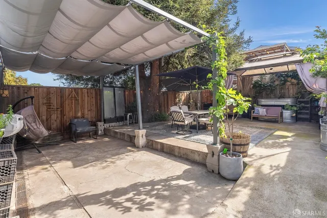 a view of patio with table and chairs under an umbrella