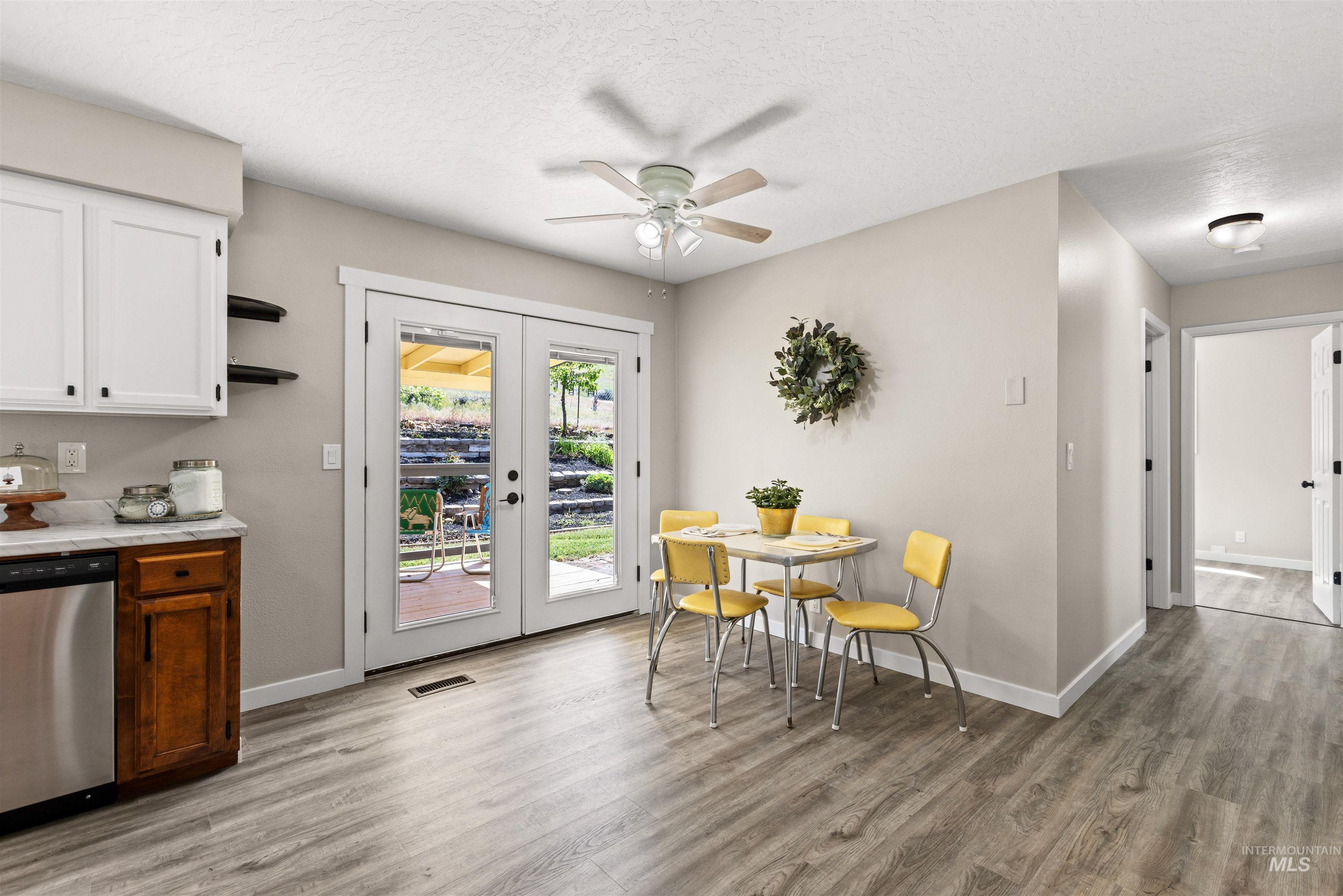 12184 Hill Road Payette, ID 83661 - Photo 18 of 35 Dining area featuring wood-finish flooring, white ceiling fan, and double French doors opening to the exterior