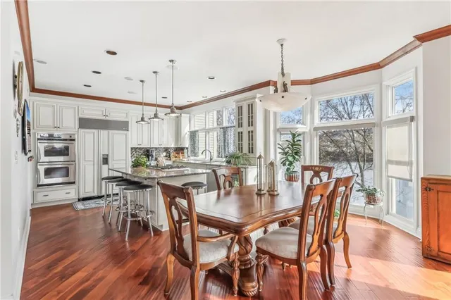 a kitchen with stainless steel appliances kitchen island wooden floors and refrigerator