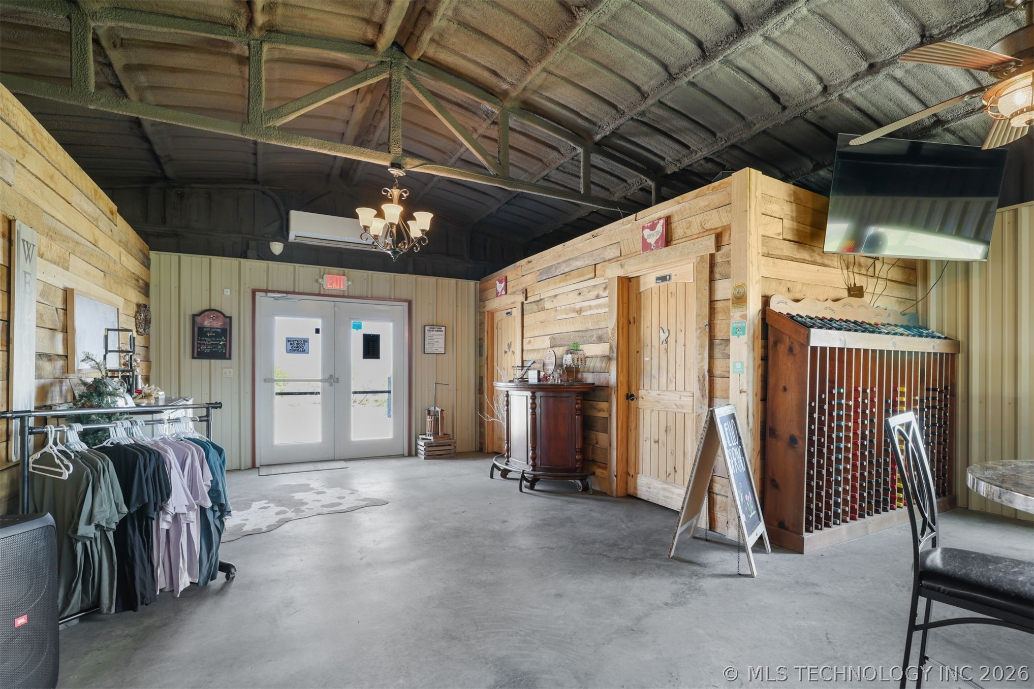 3565 Sawmill Road Caddo, OK 74729 - Photo 8 of 32 Exposed beam ceiling with a chandelier, concrete flooring, wood-paneled walls, and built-in storage