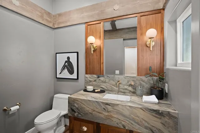 a bathroom with a toilet sink and mirror