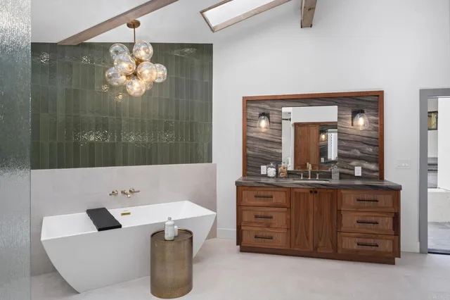 a bathroom with a granite countertop sink a mirror and bathtub