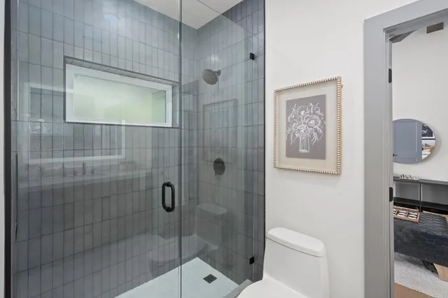 a bathroom with a shower a toilet and a sink