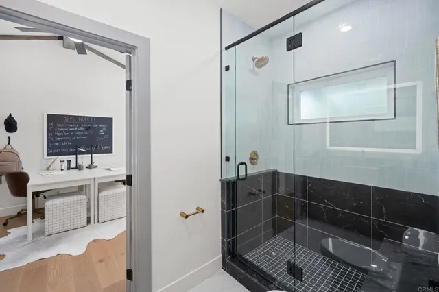 a bathroom with a sink a toilet a mirror and shower