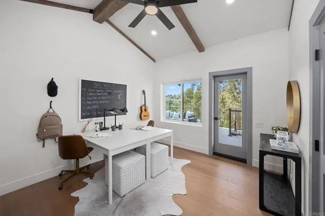 a view of a workspace with furniture and a window