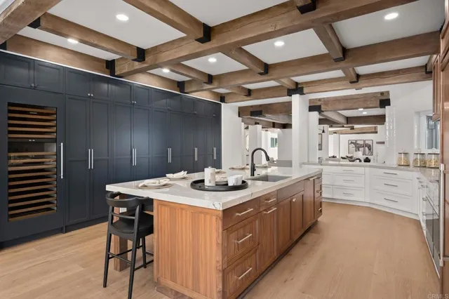 a kitchen that has a sink a stove and chairs
