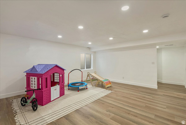 3916 South Sage Wood Avenue Mapleton, UT 84664 - Photo 22 of 33 Expansive room featuring wood-finish flooring, recessed lighting, white walls, white baseboards, and a window with horizontal blinds