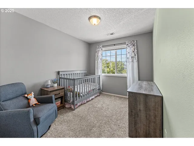 a living room with furniture and a baby crib