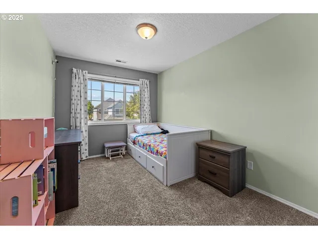 a bedroom with a bed and a painting on the wall