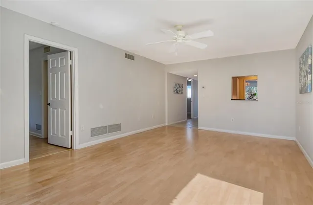 a view of an empty room with wooden floor
