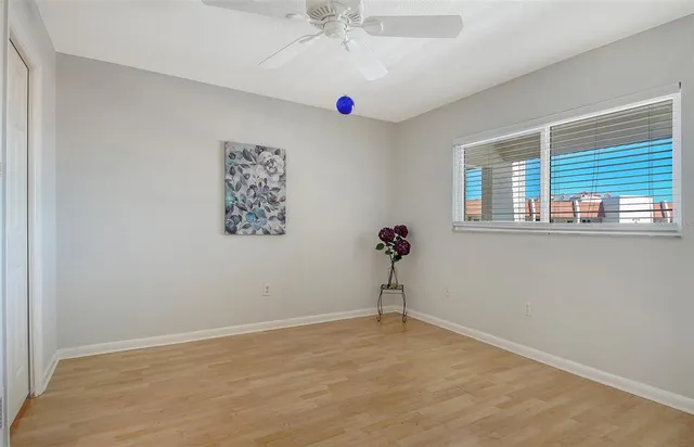 an empty room with a window and a ceiling fan