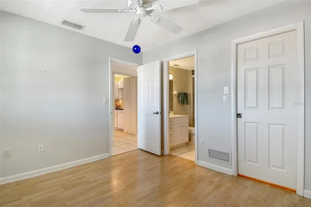 an empty room with closet and fan