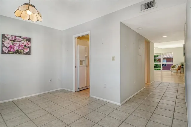 a view of a hallway to room with wooden floor