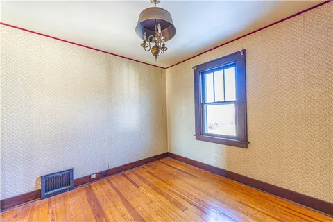 a view of a room with wooden floor and chandelier