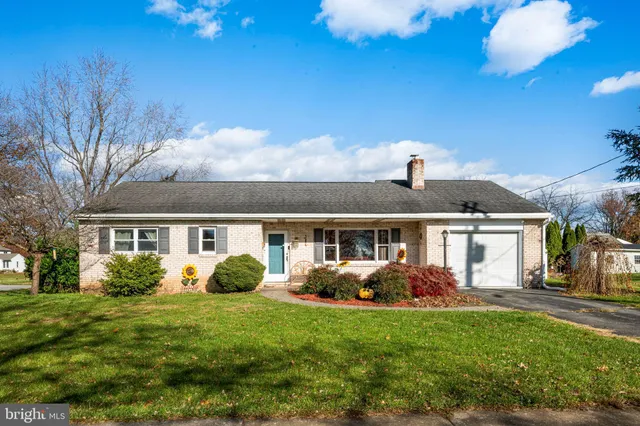 a front view of house with yard and green space