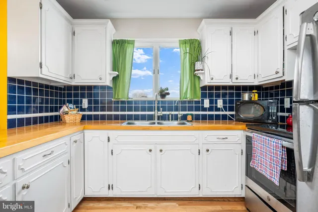 a kitchen with granite countertop a white cabinets and a sink