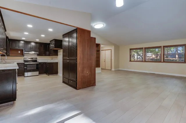 a kitchen with stainless steel appliances granite countertop a refrigerator and a stove top oven