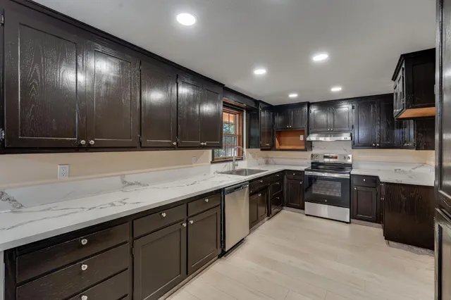 a kitchen with granite countertop stainless steel appliances and sink