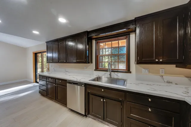 a kitchen with stainless steel appliances granite countertop a sink and a stove